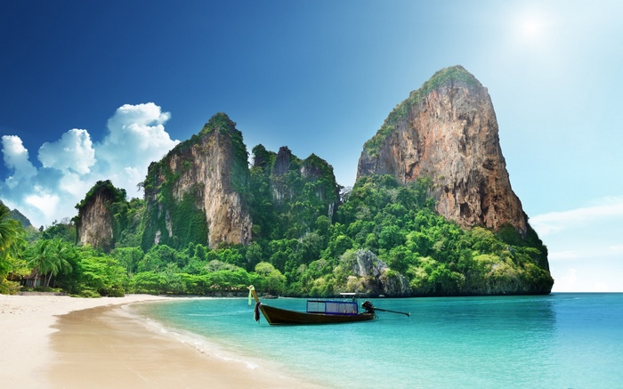 Tropical beach with limestone cliffs and a boat