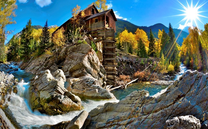 Old wooden mill by a river in autumn