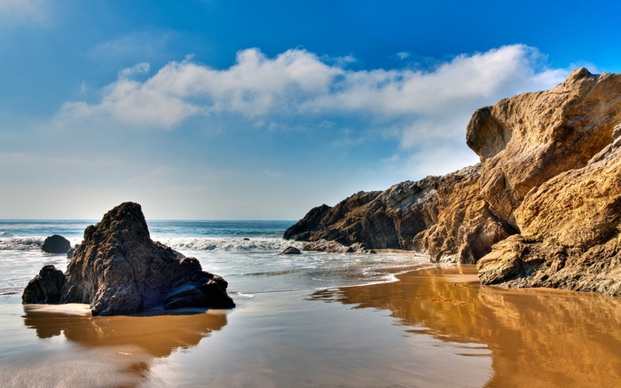 Rocky beach with waves and blue sky