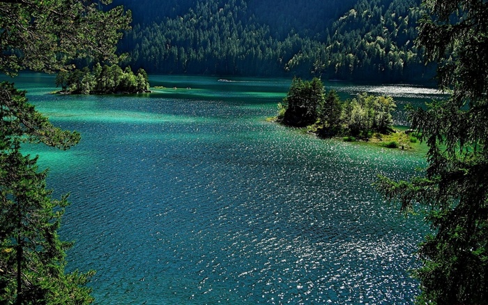 Turquoise lake surrounded by pine forest and islands