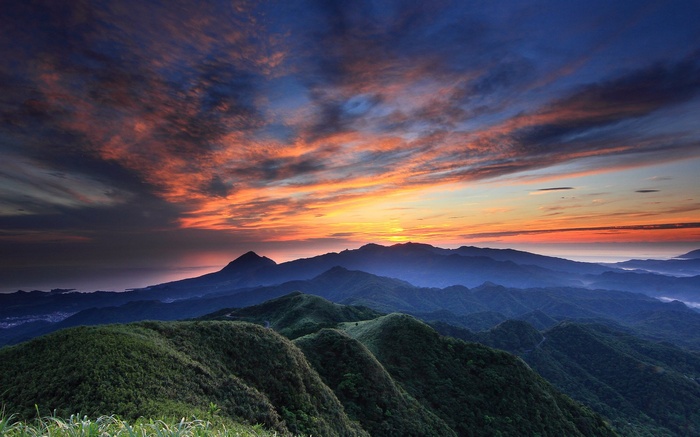 Mountain range at sunrise with colorful clouds