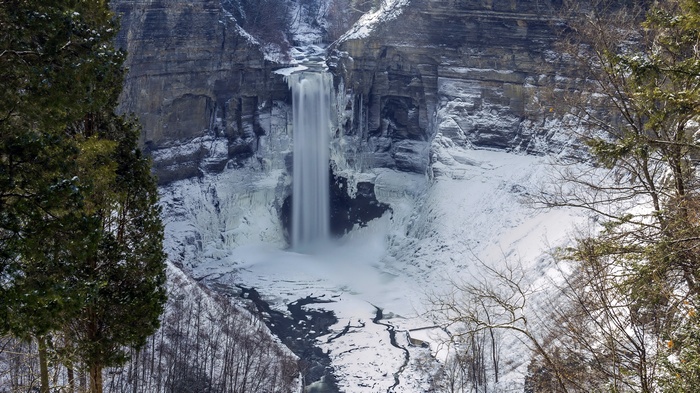 Frozen waterfall in a rocky gorge with trees