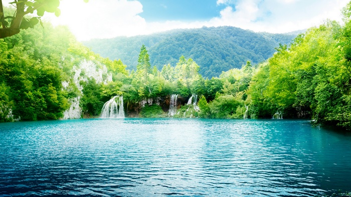 Turquoise lake with waterfalls and green mountains