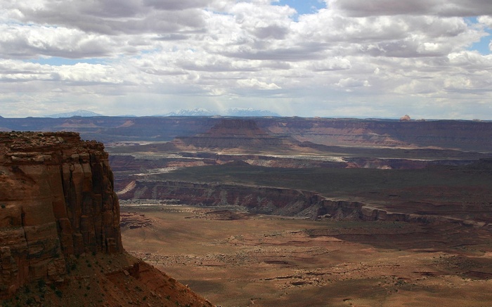 Desert landscape with mesas and distant mountains
