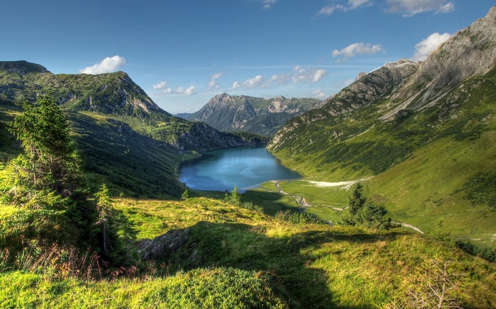Lake in a mountain valley with green slopes