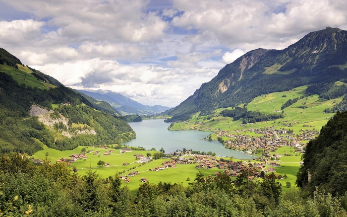 Lake and village nestled in a valley between mountains