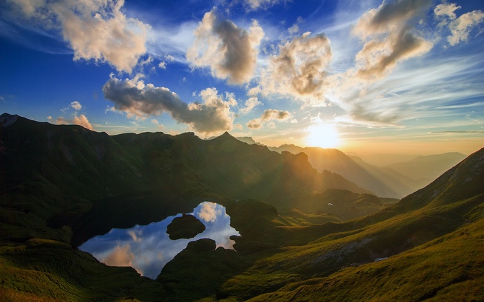 Sunset over a mountain lake with clouds