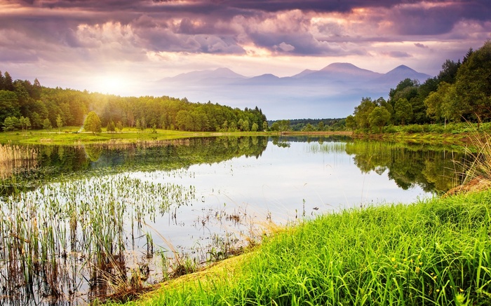 Lake reflection with mountains and forest at sunset