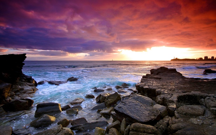Rocky coastline at sunset with colorful clouds