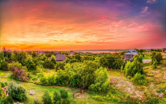 Sunset over a suburban landscape with houses and trees