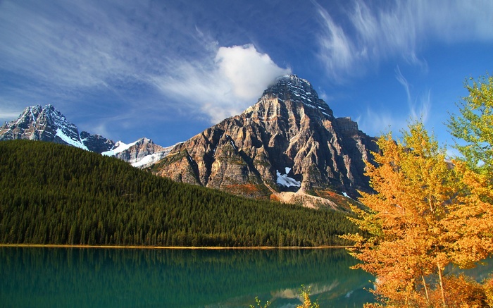 Mountain lake with autumn trees and snow-capped peaks