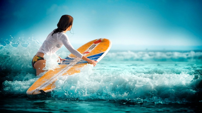 Woman with surfboard in ocean waves