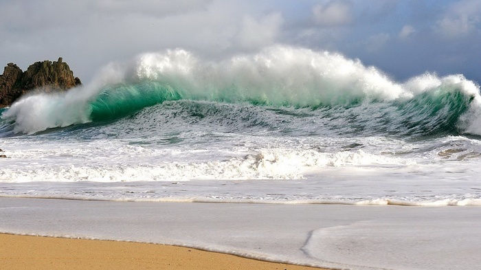 Crashing ocean wave near rocky shore
