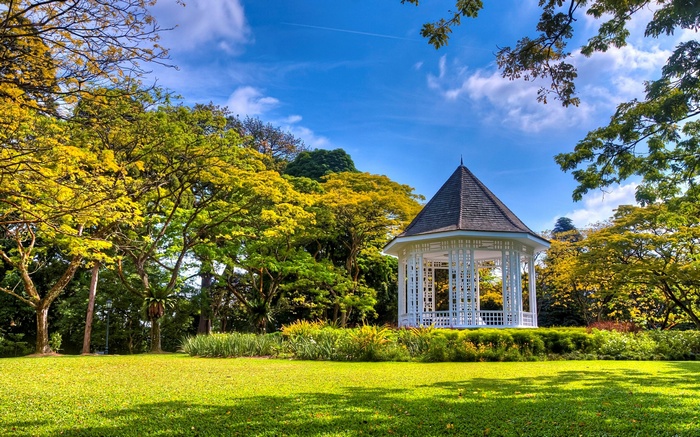 Gazebo in a park with trees and blue sky