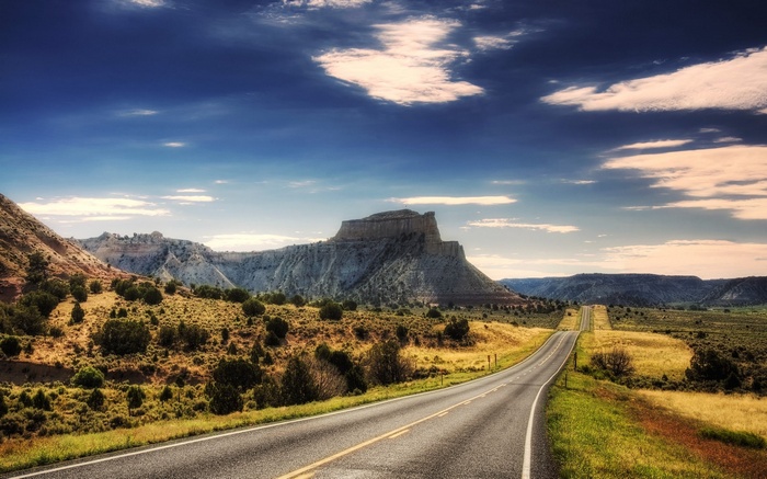 Scenic highway through a desert landscape with mesas