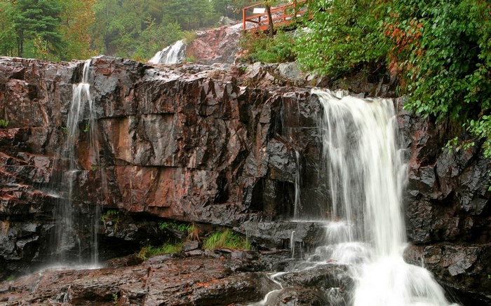 Waterfall cascading over rocky cliffs with lush greenery