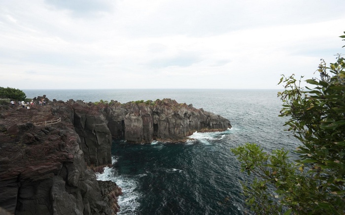 Rocky coastline with ocean and people