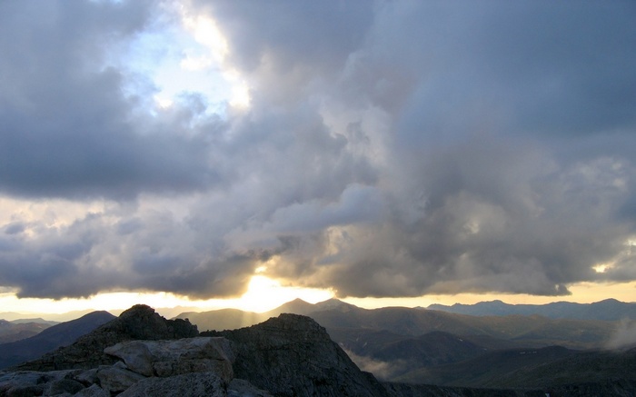 Stormy sky over mountain ranges at sunset