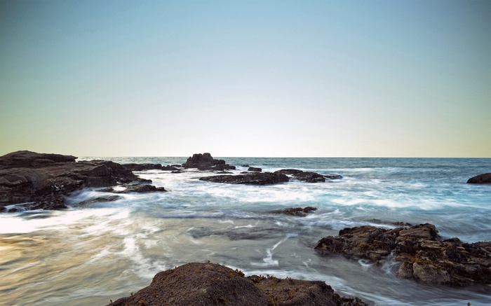 Ocean waves crashing on rocky shore