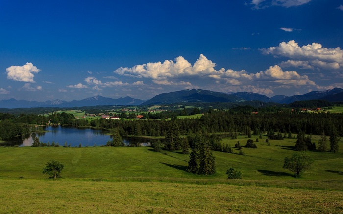 Green rolling hills with a lake and mountains