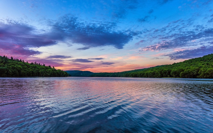 Lake and forest at sunset with colorful sky