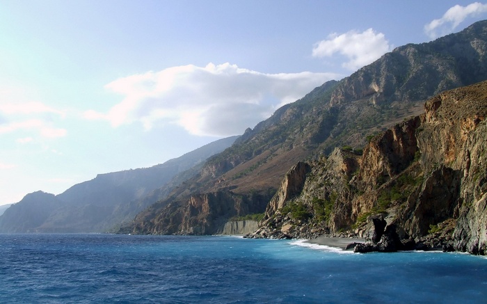 Rocky coastline with blue ocean and mountains