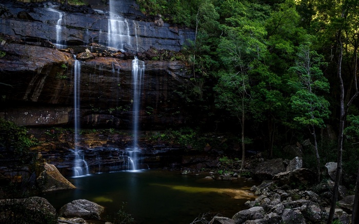 Waterfall cascading down a rocky cliff into a pool