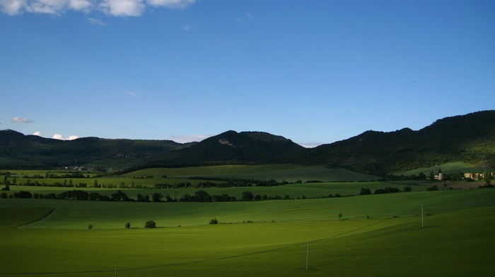 Green fields and rolling hills under a blue sky