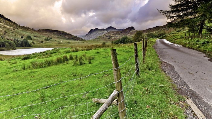 Rural road with fence and mountains