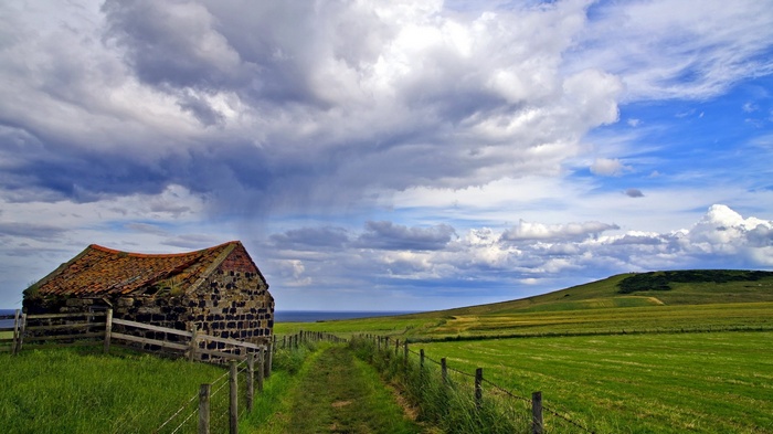 Abandoned stone building on a grassy hill