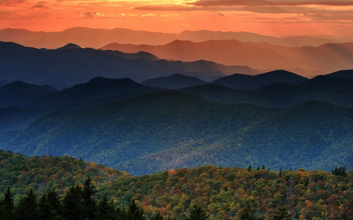 Mountain layers at sunset with orange sky