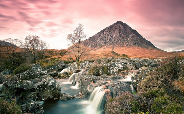 Mountain landscape with a waterfall and pink sky
