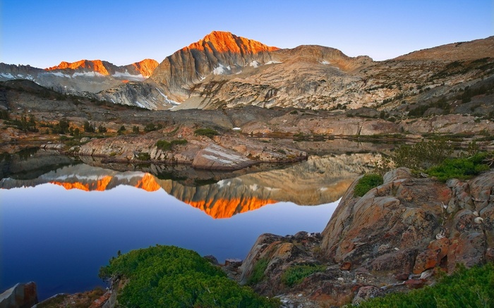 Mountain lake reflecting sunset on peaks