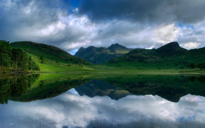 Mountain lake reflection under cloudy sky
