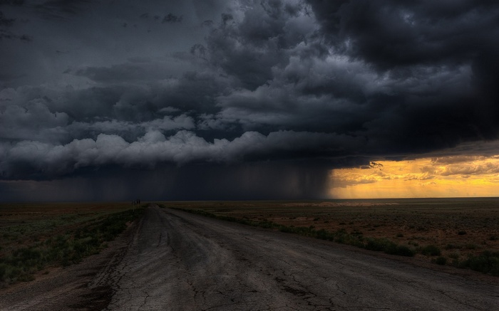 Stormy sky over a dirt road in a field