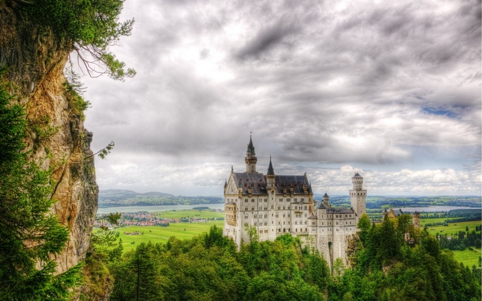 Neuschwanstein Castle on a cliff overlooking a valley