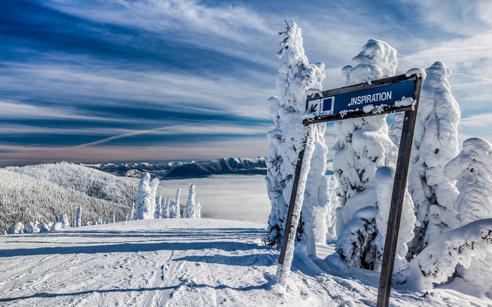 Ski slope signpost in snowy mountains