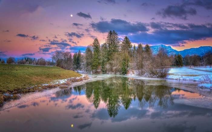 Winter landscape with lake and mountains at sunset