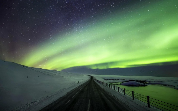 Aurora Borealis over a snowy road in Iceland