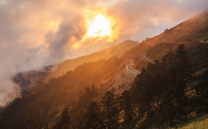 Mountain road at sunset with clouds
