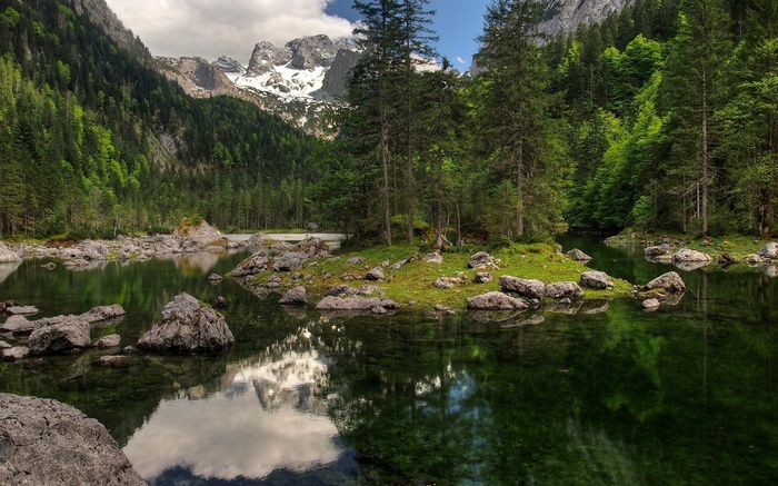 Mountain lake with rocky islands and evergreen forest