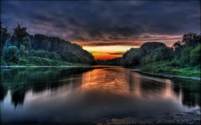 River flowing through a forest at sunset