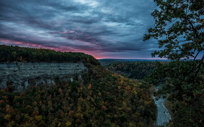 River valley with cliffs and forest at sunset