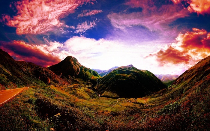 Mountain valley with colorful sky and road