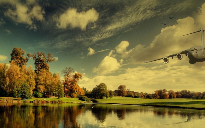 Airplane flying over a lake and autumn trees