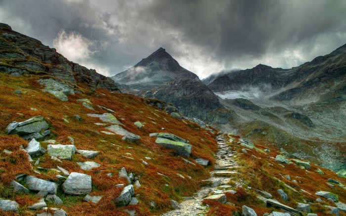 Mountain path with rocky terrain and cloudy sky
