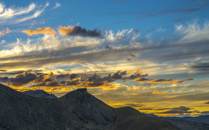 Sunset clouds over mountainous terrain