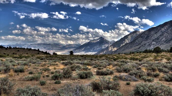 Mountain range with dry brush and dramatic clouds