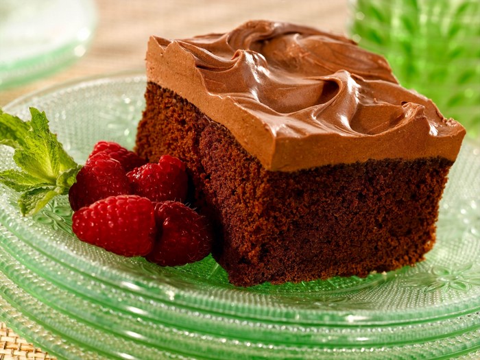 Chocolate cake slice with raspberries and mint