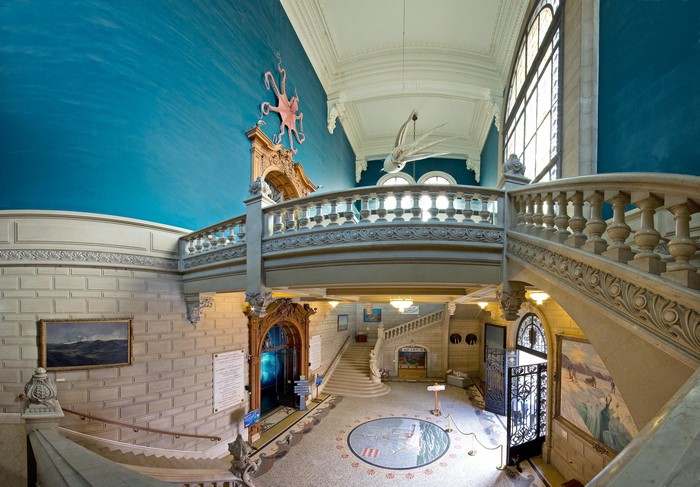 Interior of a grand hall with a blue ceiling and marine decorations